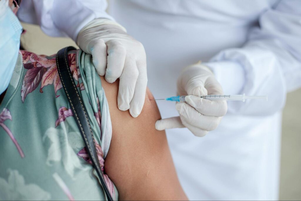 Person receiving a flu shot in their arm