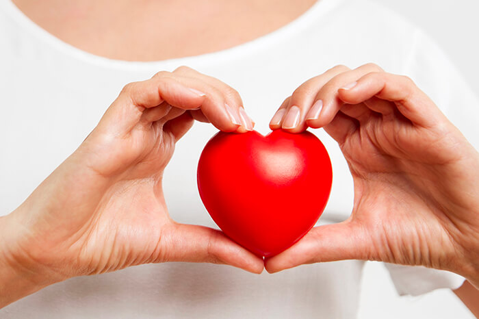 Woman holding red heart for heart health