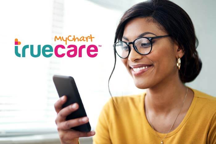 truecare-mychart-featured-image-blog-700×466-2 Mujer mirando su teléfono inteligente